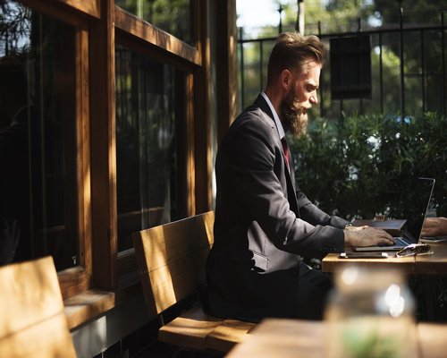 Person working comfortably on a laptop near a bright window