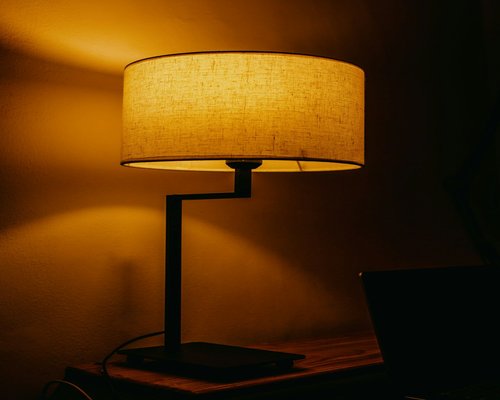 A desk lamp providing warm light for evening reading