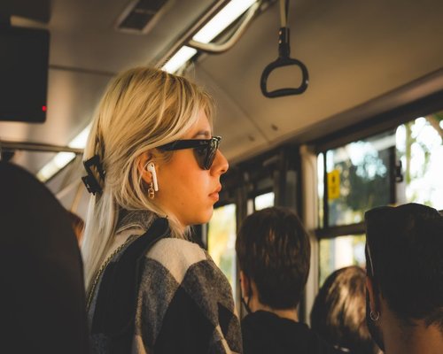 Commuter listening to a podcast on a bus in a busy city