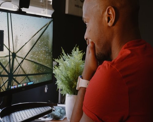 Person looking away from a computer screen out the window